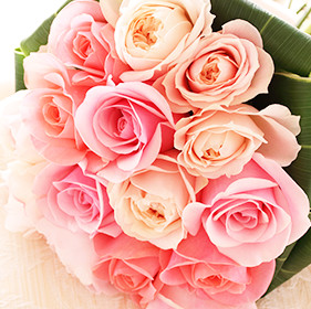 ピンクや薄いオレンジのバラの花束